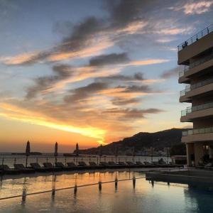a sunset over a body of water next to a building at Konstantinos Palace in Karpathos