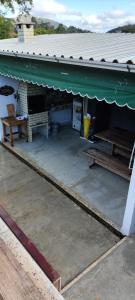 a building with a green awning and a table and bench at Pedaço da serra in Teresópolis