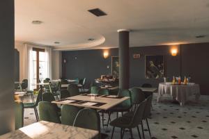 a dining room with tables and green chairs at Hotel Villa Maria Au Lac - Gruppo Estella Hotels in Toscolano Maderno