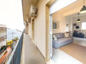 Una sala de estar con un sofá y vista al mar. en Casteldaci Sea house - Exclusive brand "Holiday in the CT", en Aci Castello