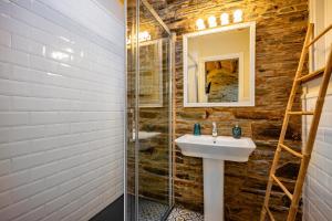 une salle de bain avec un lavabo et une douche en verre dans l'établissement Ático Casa Venancio, à Trabada 15 autres photos