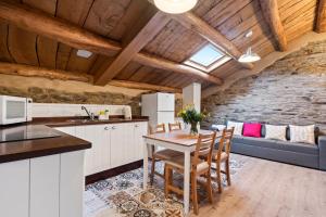 une cuisine et un salon avec une table et des chaises dans l'établissement Ático Casa Venancio, à Trabada