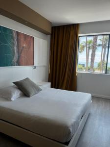 a bedroom with a large bed with a large window at SoBlue Hôtel in Antibes