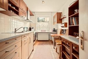 a kitchen with wooden cabinets and a sink at Ferienwohnung Louise 50 m zum See in Kressbronn am Bodensee +11 photos