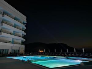 a swimming pool in front of a building at night at Konstantinos Palace in Karpathos