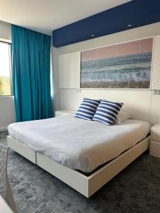 a bedroom with a large bed with blue walls at SoBlue Hôtel in Antibes