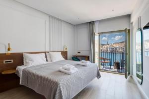 a bedroom with a bed with towels on it at Eclectic Syros in Ermoupoli +67 photos