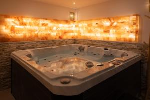 a large bath tub in a room with at L'Andalouse - SPA Privatif - Jacuzzi Hammam Sauna in Mittelhausbergen
