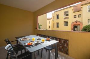 a balcony with a table with food and drinks on it at Macdonald Doña Lola Resort in La Cala de Mijas