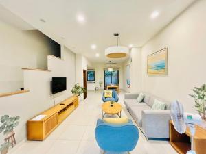 a living room with a couch and a tv at Villa 102 - villa 114 royal lotus, Hùng Thắng, Hạ Long, Quảng Ninh in Ha Long