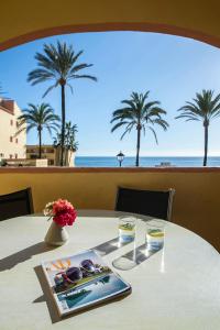 a table with a view of the ocean and palm trees at Macdonald Doña Lola Resort in La Cala de Mijas