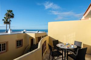 a balcony with a table and chairs and the ocean at Macdonald Doña Lola Resort in La Cala de Mijas