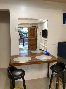 a counter with three stools in a room with a mirror at RACHEL's INN in Dumaguete
