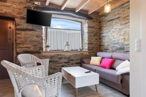 un salon avec un canapé, des chaises et une télévision dans l'établissement A Corte, à Trabada
