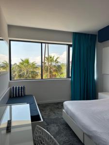 a hotel room with a bed and a large window at SoBlue Hôtel in Antibes