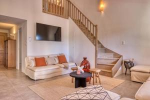 a living room with a couch and a staircase at VILLA Isle sur la Sorgue in LʼIsle-sur-la-Sorgue