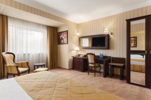 a hotel room with two beds and a television at Ramada Hotel & Suites by Wyndham Bucharest North in Bucharest