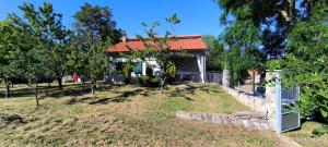 a house with a red roof in a field at AnteAna Vrlika Split in Maovice