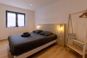 a bedroom with a bed with a teddy bear on it at La Palmeraie & SPA Privé - Jacuzzi Hammam Sauna in Mittelhausbergen