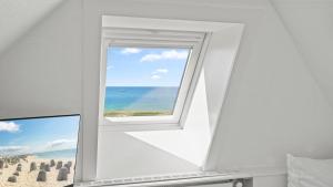 a window in a room with a view of the beach at Gurtdeel 1000 Sterne-Suite in Hörnum +1 photo