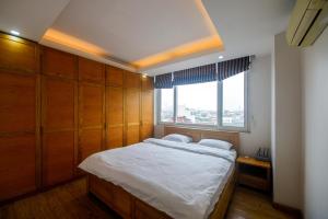 a bedroom with a large bed and a window at Hồ Ba Mẫu Apartment LilyHome in Hanoi