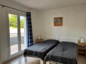 a bedroom with a bed and a sliding glass door at PALMERAIE 220 in Sari Solenzara +11 photos