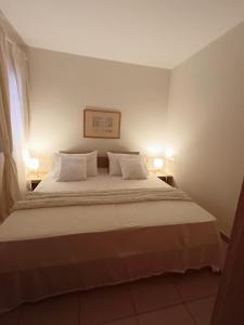 ein Schlafzimmer mit einem großen weißen Bett mit zwei Lampen in der Unterkunft Atlantico breeze in Costa Del Silencio