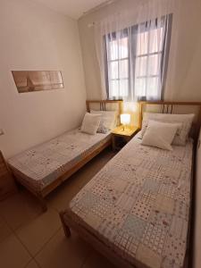 zwei Betten in einem Zimmer mit Fenster in der Unterkunft Atlantico breeze in Costa Del Silencio + 3 Fotos
