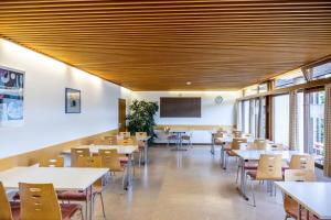 een eetkamer met tafels en stoelen en een scherm bij Jugendherberge Schluchsee-Wolfsgrund in Schluchsee