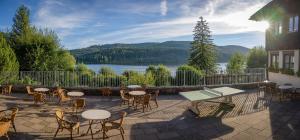 een patio met tafels en stoelen en uitzicht op een meer bij Jugendherberge Schluchsee-Wolfsgrund in Schluchsee