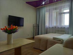 a hotel room with a bedroom with a bed and a tv at Лунная Гавань in Aktobe +34 photos