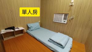 a small bed in a room with a yellow sign at 綠島包棟 Beer Inn in Green Island +18 photos