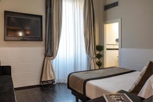 una camera d'albergo con un letto e una TV a schermo piatto di The Independent Suites a Roma