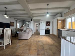 a kitchen and living room with a white refrigerator at Villas Dehesa Roche Viejo in Conil de la Frontera