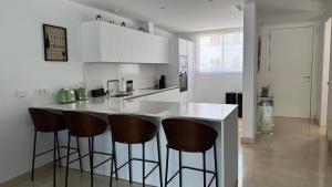 a kitchen with a counter with bar stools at Serenity by the Sea in La Valvega, La Cala de Mijas in La Cala de Mijas