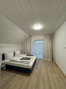 una camera da letto con un letto e una grande finestra di Apartament Paula SPA Niechorze a Niechorze
