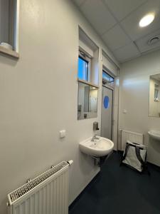 a white bathroom with a sink and a mirror at Sopot Classic Boat in Sopot