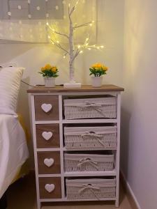 a dresser with flowers and a tree on top of it at Condado de Alhama Jardin 11 SV51 in Alhama de Murcia