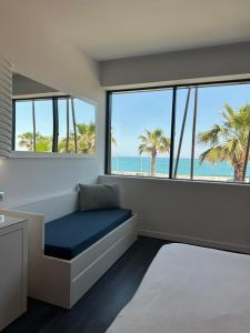 a room with a couch and a view of the beach at SoBlue Hôtel in Antibes