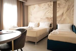 雷焦卡拉布里亚Didimos Town Hotel的有两张床和一张书桌的酒店房间