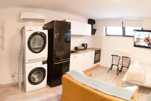 a kitchen with a refrigerator and a washer and dryer at Cozy Condo in Tresnjevka in Zagreb