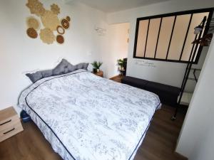 a bedroom with a bed with a blue comforter at Grain de Sable Vue Mer in Woignarue