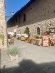 a patio with tables and chairs in front of a building at Affittacamere Dodo - Borgo di Filetto in Filetto