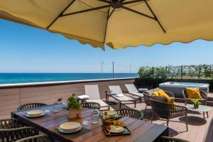eine Terrasse mit Tischen und Stühlen und einem Sonnenschirm in der Unterkunft Luxury terrazza in Bari