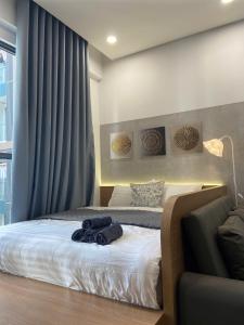 a bedroom with a bed with blue towels on it at Lustay StudioH3 Hawaii Masteri- Luxury Furnished in Gia Lâm Pho