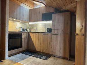 a kitchen with wooden cabinets and a stove at Apartment 162 - Bristol in Villars-sur-Ollon