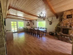 a large living room with a table and chairs at Pensiunea Poiana Cerbului in Tarcău-Gheuca