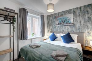 a bedroom with a large bed with blue pillows at Spacious 4 Bed Preston Home with Garden & Parking in Preston