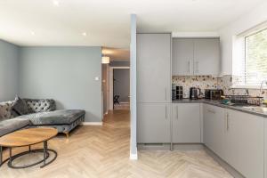 a kitchen and a living room with a couch and a table at Modern & Stylish 3 Bedroom Home in Peterborough in Peterborough