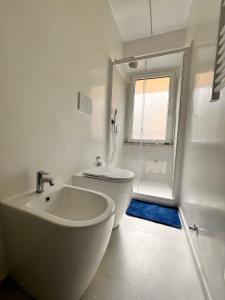 a bathroom with a sink and a toilet and a window at Sweet Home in San Rocco in Bolsena